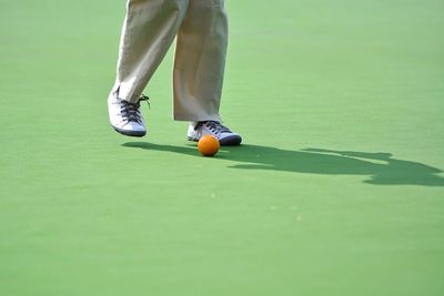 Low section of man playing lawn bowling at playing field
