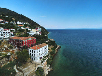 High angle view of buildings by sea against sky