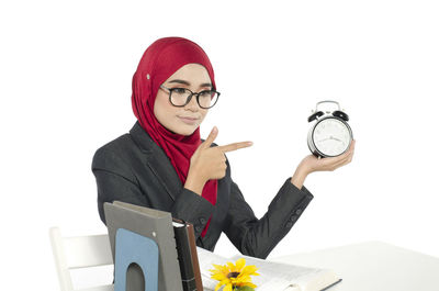 Full length of a young woman sitting against white background