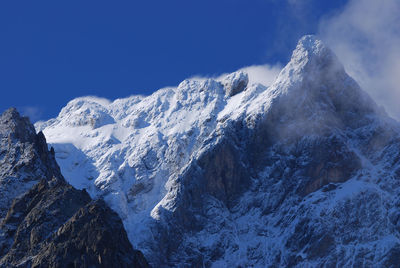 Scenic view of snowcapped mountains against blue sky