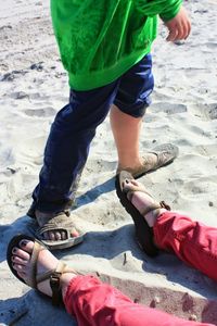 Low section of man standing on beach