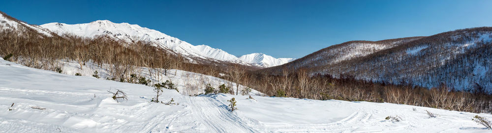 Scenic view of snowcapped mountains against clear sky