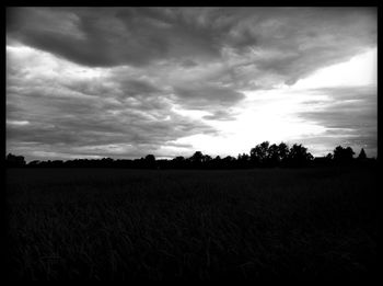 Scenic view of field against cloudy sky