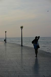 Full length of silhouette woman on beach against sky during sunset