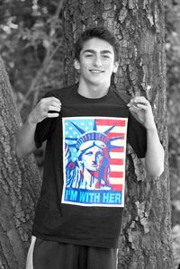 Portrait of smiling boy standing by tree trunk