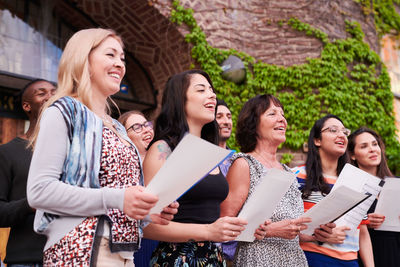 Multi-ethnic students singing in choir together outside language school