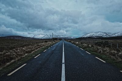 Road leading towards mountain against sky