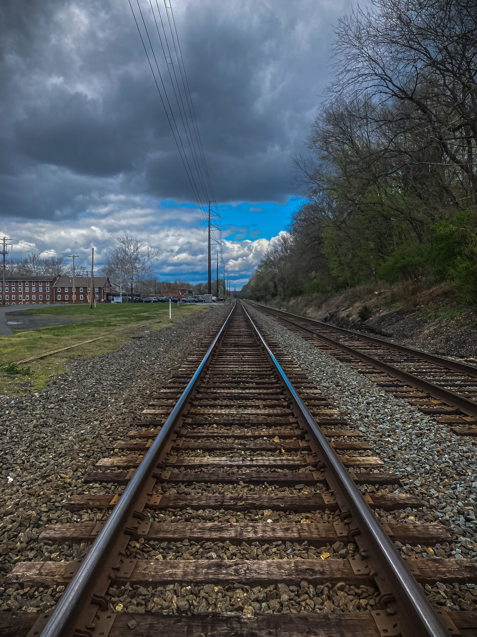 railroad track, track, rail transportation, cloud, sky, transportation, transport, vanishing point, nature, the way forward, diminishing perspective, no people, railway, electricity, mode of transportation, cable, tree, vehicle, environment, architecture, outdoors, plant, public transportation, parallel, storm, travel, line, straight