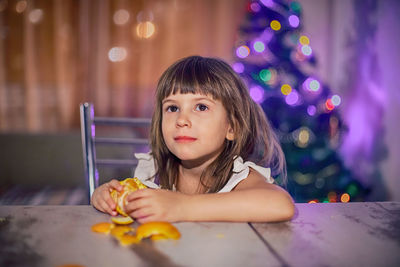 Young woman looking away while sitting on bed