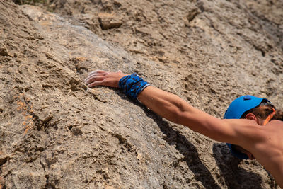 Close-up of shirtless man rock climbing 