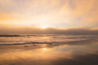 Beach sunset with marine layer clouds moving in creating a golden glow and  a misterious feeling