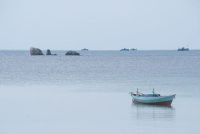 Boats in sea against clear sky