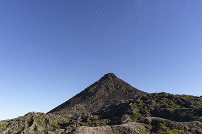 Low angle view of mountain against clear blue sky, top of pico island volcano