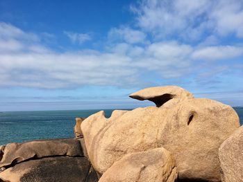 Rock formations by sea against sky