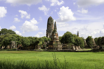 View of temple on field against cloudy sky