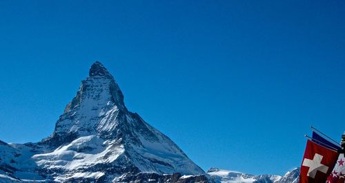 Scenic view of snowcapped mountains against clear blue sky