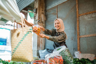 Low angle view of young woman standing against wall