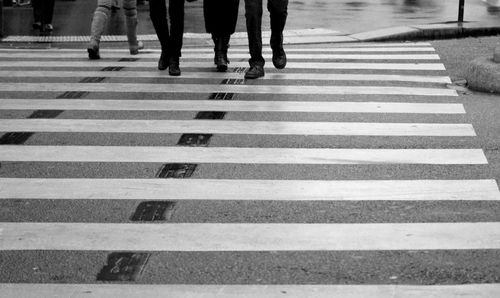 Low section of people walking on zebra crossing