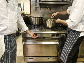 Midsection of man preparing food in kitchen