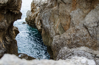 Rock formations by sea against sky