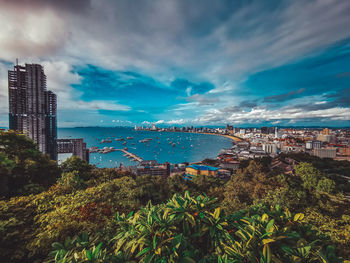 Scenic view of city by sea against sky