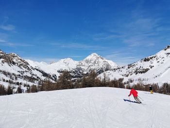 Snowcapped mountain range against sky during winter