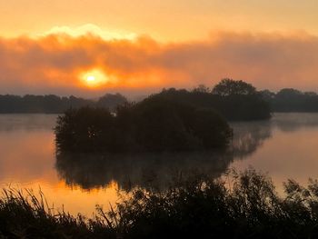 Scenic view of lake against orange sky