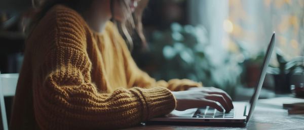 Midsection of woman using laptop