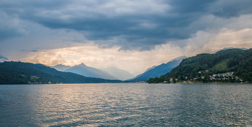 Scenic view of lake by mountains against sky