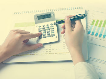 Close-up of hand holding smart phone on table