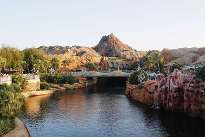 Scenic view of river by mountains against clear sky