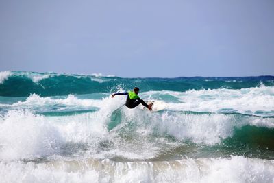 Man surfing in sea against sky