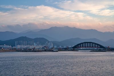 Scenic view of sea by city against sky during sunset