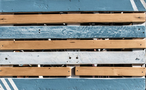 Row of wooden chairs against building