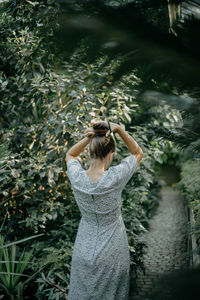 Rear view of woman standing by plants