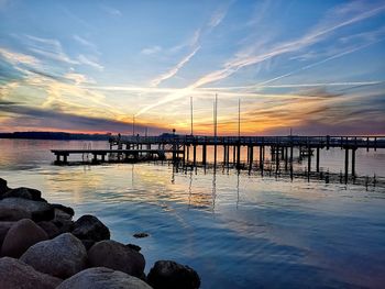 Pier over sea against sky during sunset