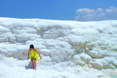 Full length of woman standing on pamukkale against sky