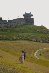 Woman standing at historical building against sky