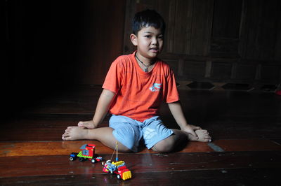 Portrait of boy playing with toy sitting on floor