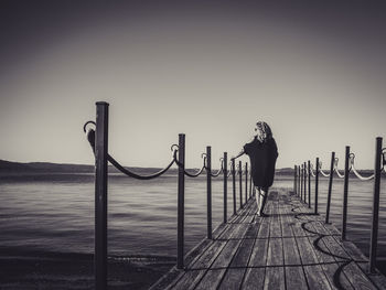 Silhouette people walking on pier