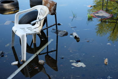 Broken chairs and tires in water on field