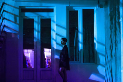 Woman standing against blue wall