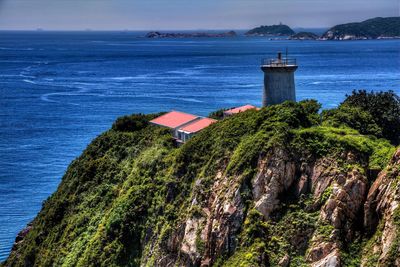 Lighthouse on cliff by sea at cape d aguilar