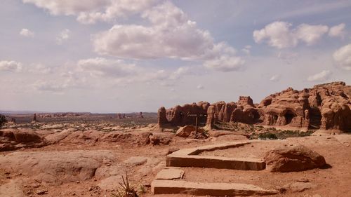 Desert landscape with rock formation against sky 