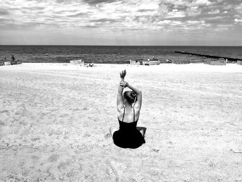 Man wearing sunglasses on beach against sky