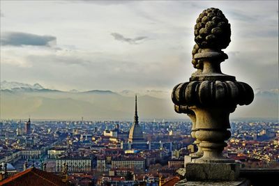 Statue in city at sunset