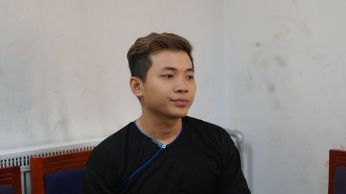 Young man standing against wall