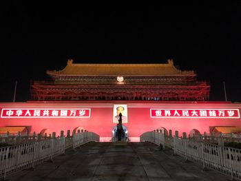 Man standing in illuminated building at night