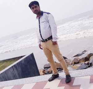 Portrait of young man standing on beach