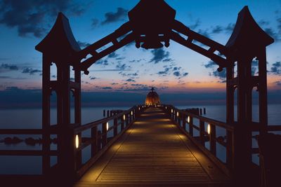 Bridge over sea against sky during sunset